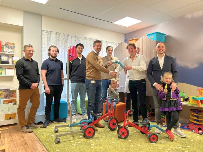 Overhandiging infuusfiets. V.l.n.r.: Jeroen van den Bosch (Ideeënfabriek CIVON), student Ruben Koehorst (Graafschap College), Ayden Persad (HAN University of Applied Sciences), Edwin Maalderink (bestuurder SKB), Kayh Arink (Tafelronde 42) met zoon Noah
